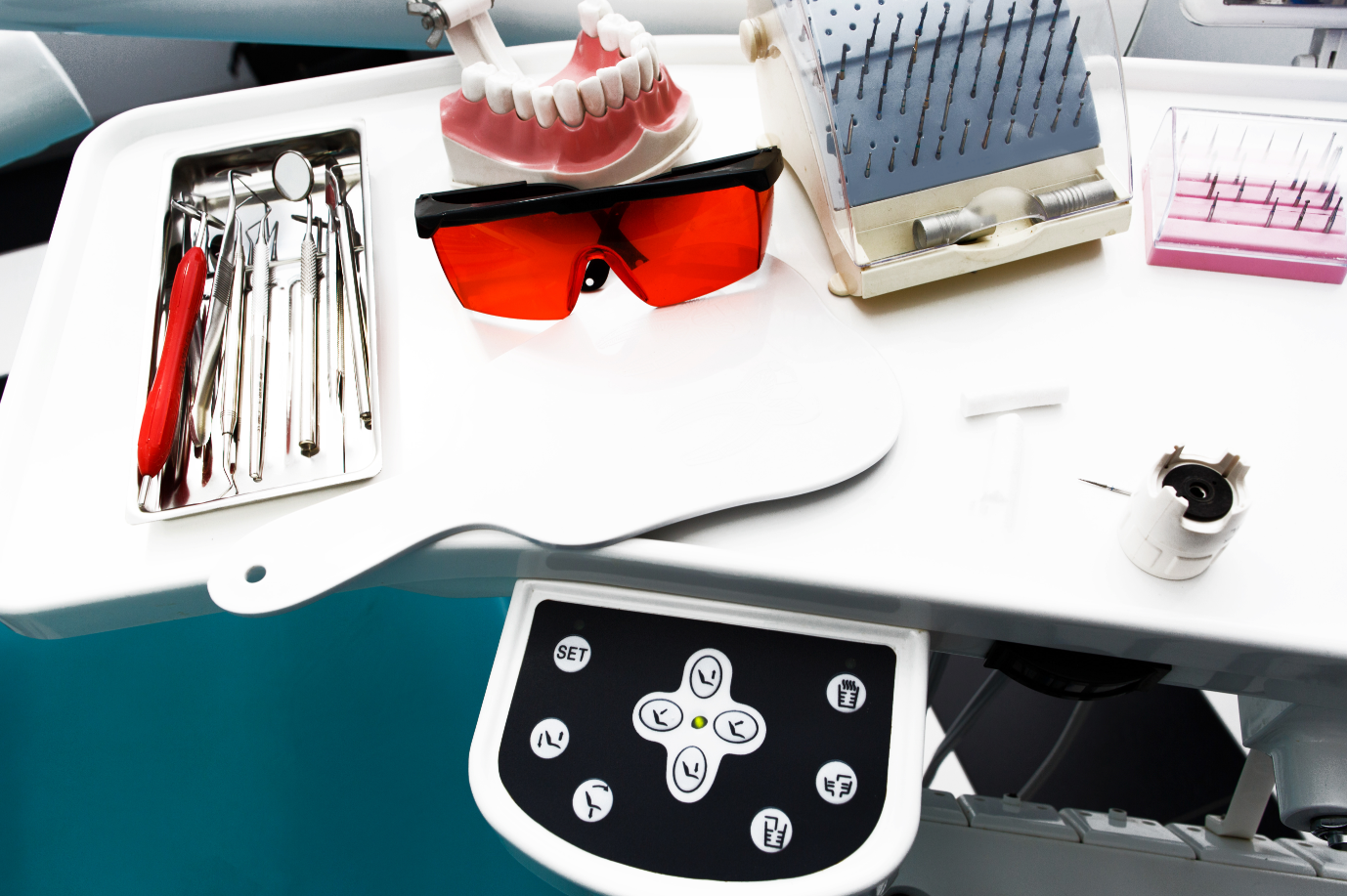 A dental workstation with various tools, including a model of teeth and protective glasses