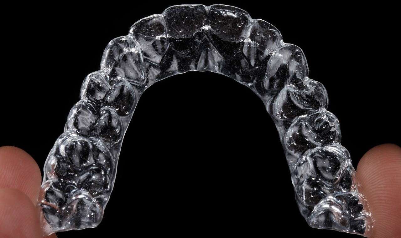 Clear Invisalign aligner tray showing custom-fit transparent orthodontic appliance for teeth alignment