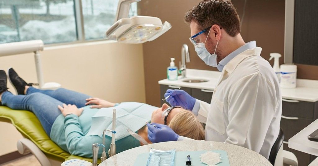 Dentist performing a dental implant procedure on a patient in a modern dental clinic.